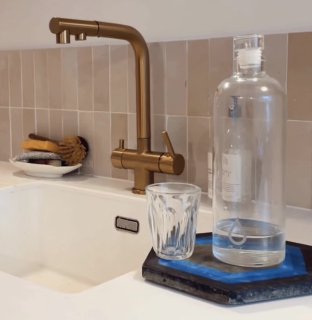 Robinet doré avec verre d'eau, cuisine carrelée — Glouglou OSMO ONE